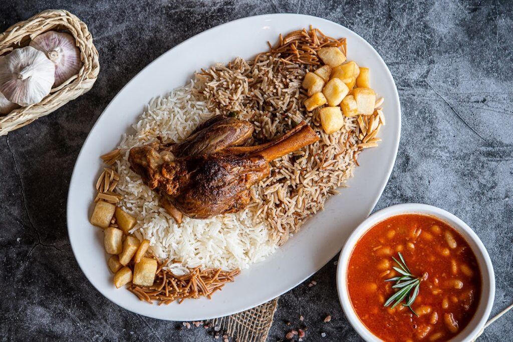 طبق من المطبخ العراقي من مطعم جمار العراقي مكون من الأرز الأبيض والبري مع ساق الدجاج المشوي، يرافقه البطاطس المقلية المقطعة وطبق جانبي