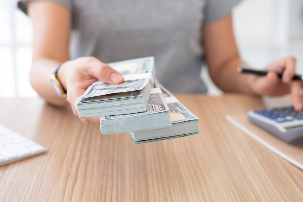 أمرأة تحمل ثلاث رزم من المال